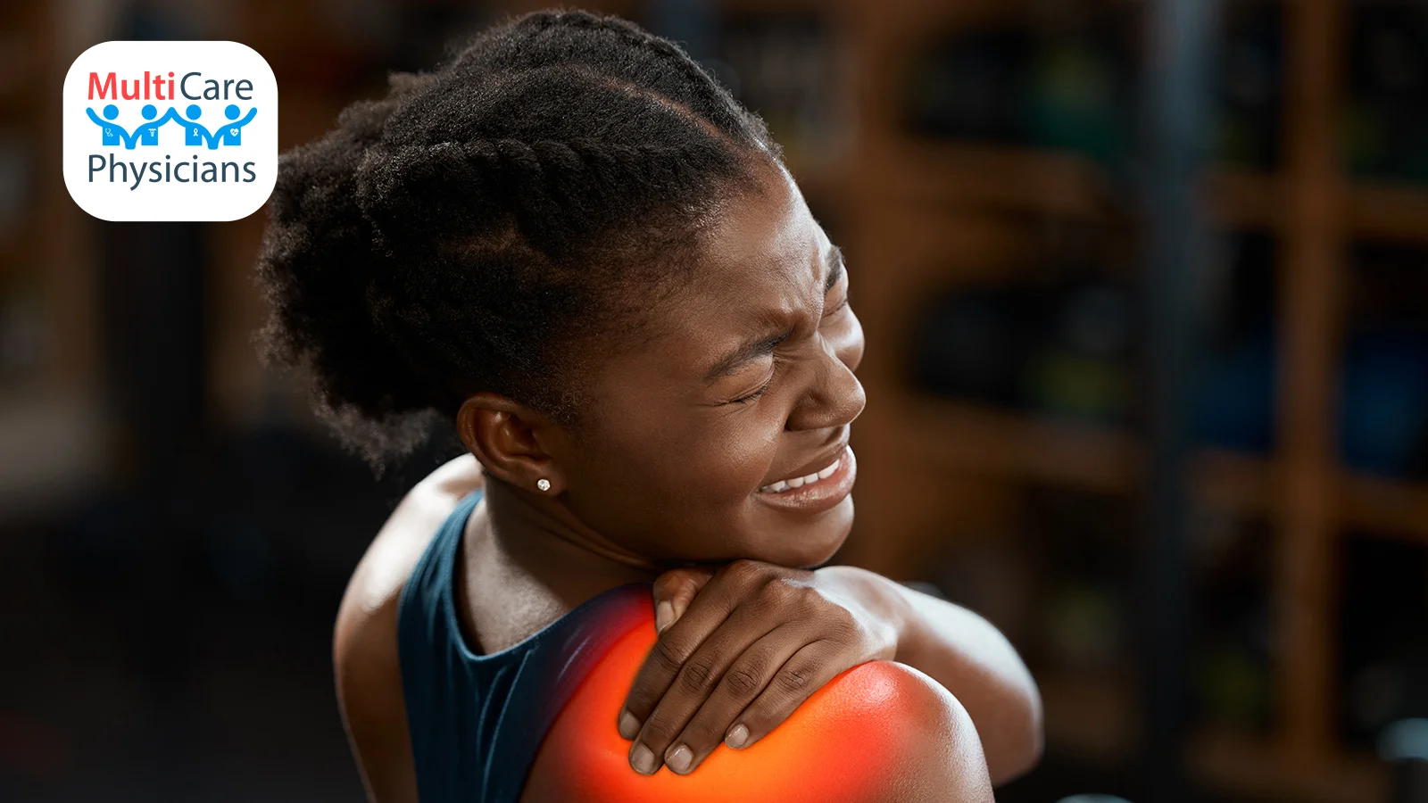 A woman experiencing intense shoulder pain, grimacing while holding the affected area. Highlighted inflammation suggests severe discomfort. MultiCare Physicians provides urgent care services for musculoskeletal injuries, ensuring quick relief and expert treatment.