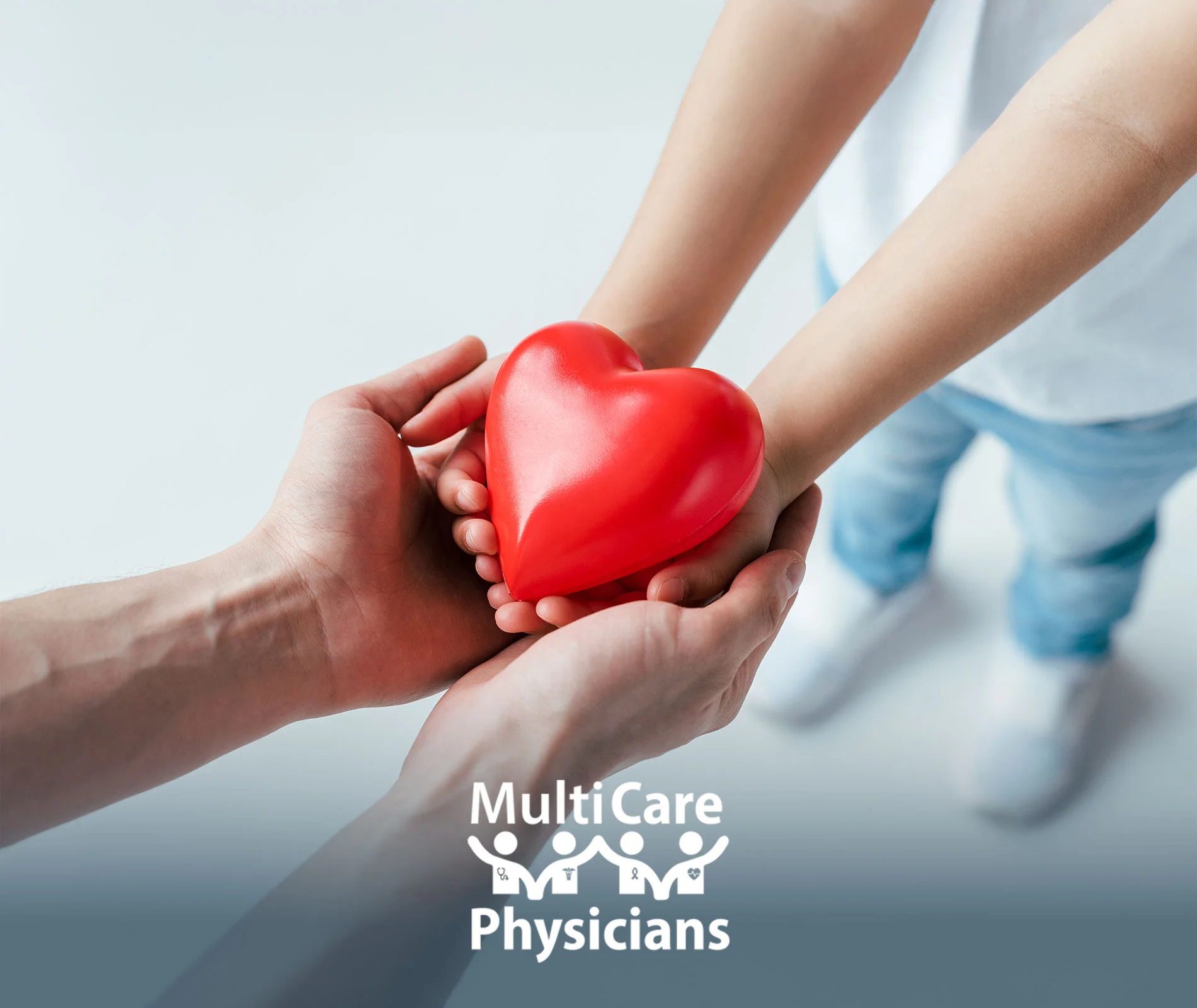 Close-up of adult and child hands holding a red heart, symbolizing care, prevention, and awareness for Heart Failure—MultiCare Physicians.